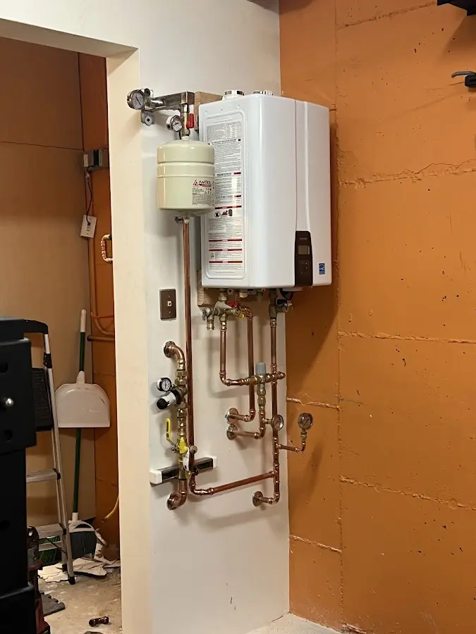 Plumbing technician inspecting water heater connections in Clemson University